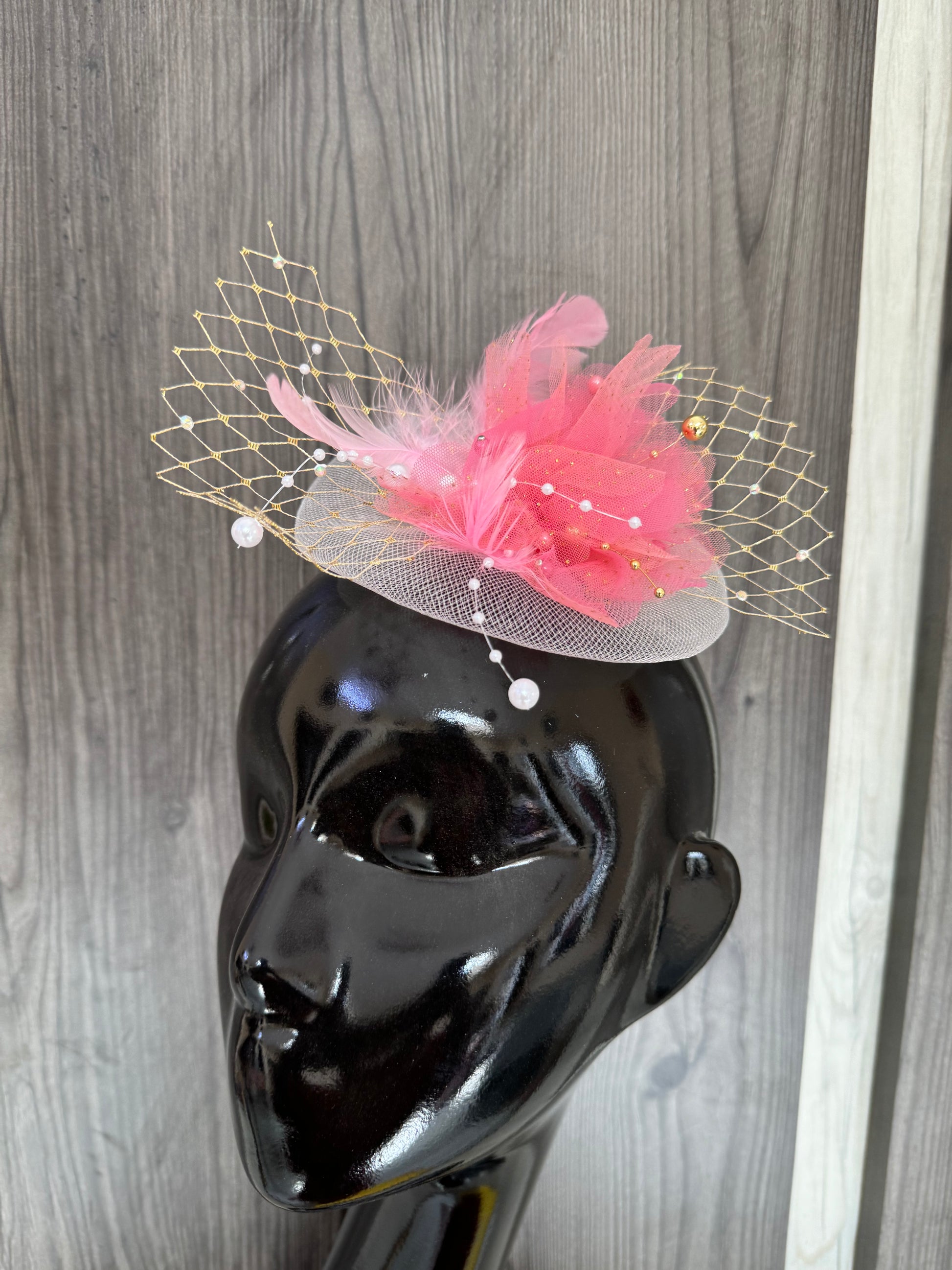 White Fascinator har with pink flower, feather and small golden birdcage veil